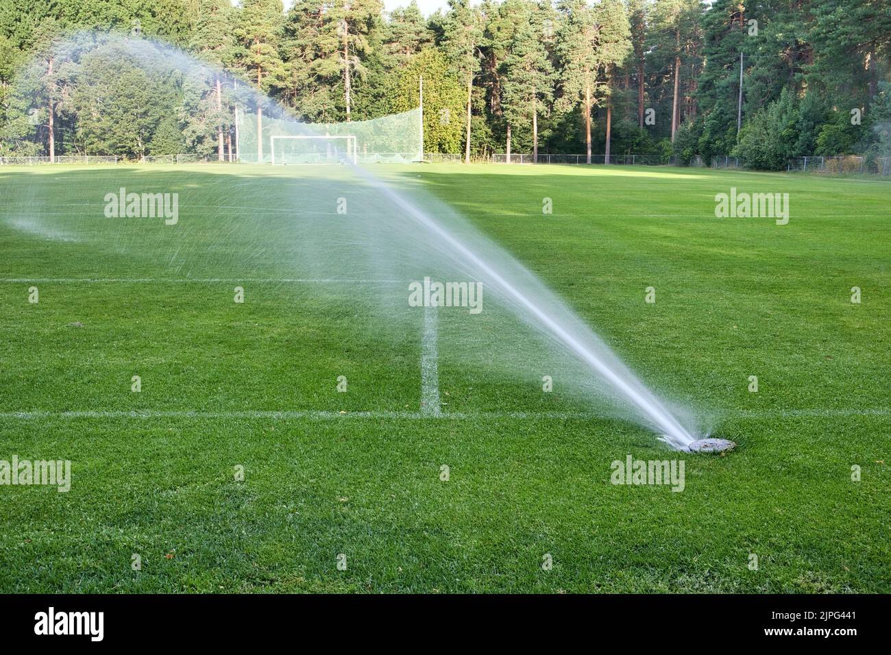in-ground sprinkler system watering the sports field Stock Photo