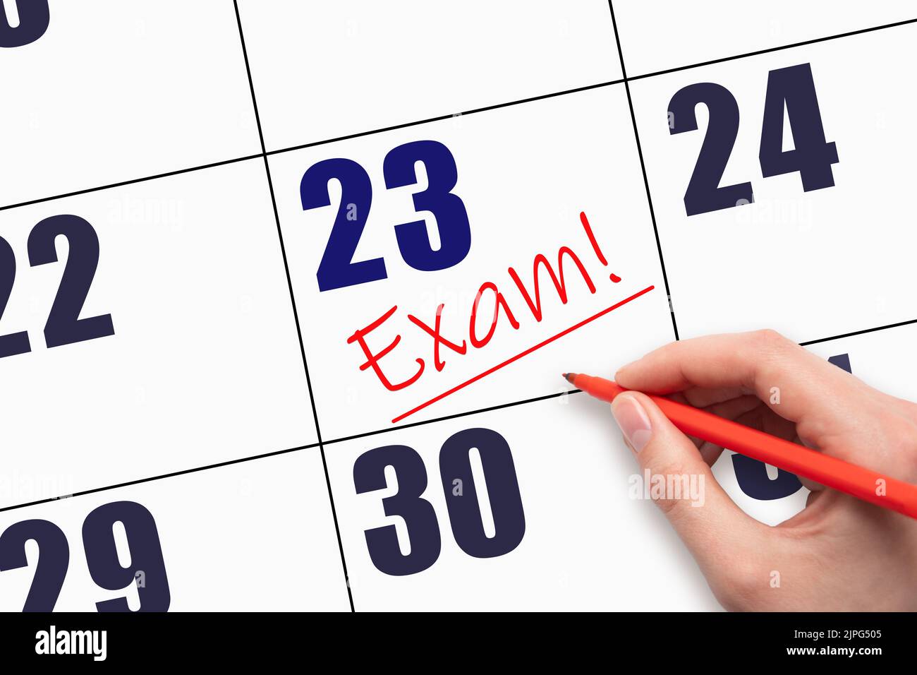 23rd day of the month. Hand writing text EXAM and drawing a line on ...