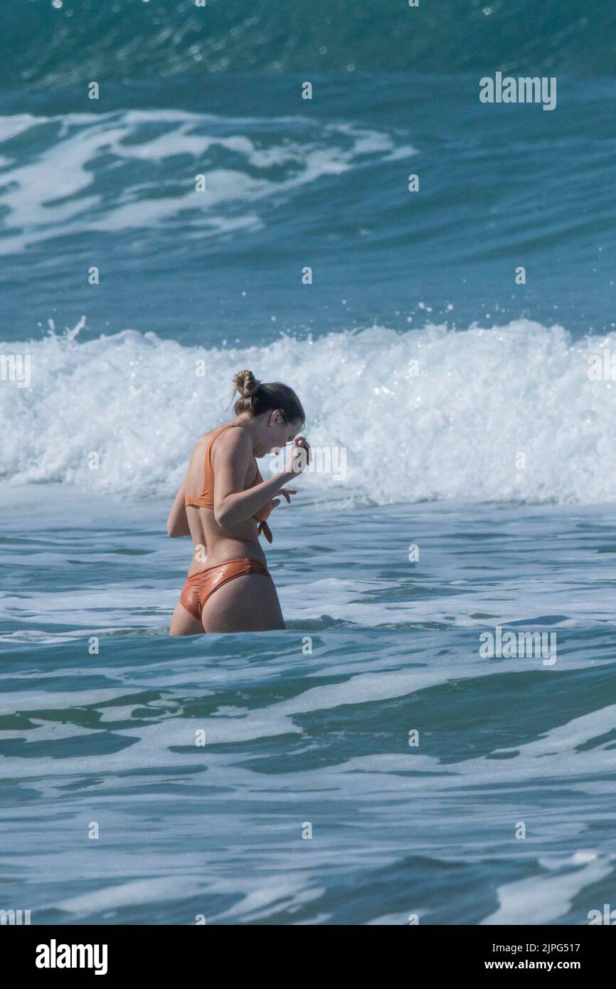 A female holidaymaker in a bikini walking into of the sea at Fistral Beach in Newquay in Cornwall in the UK. Stock Photo