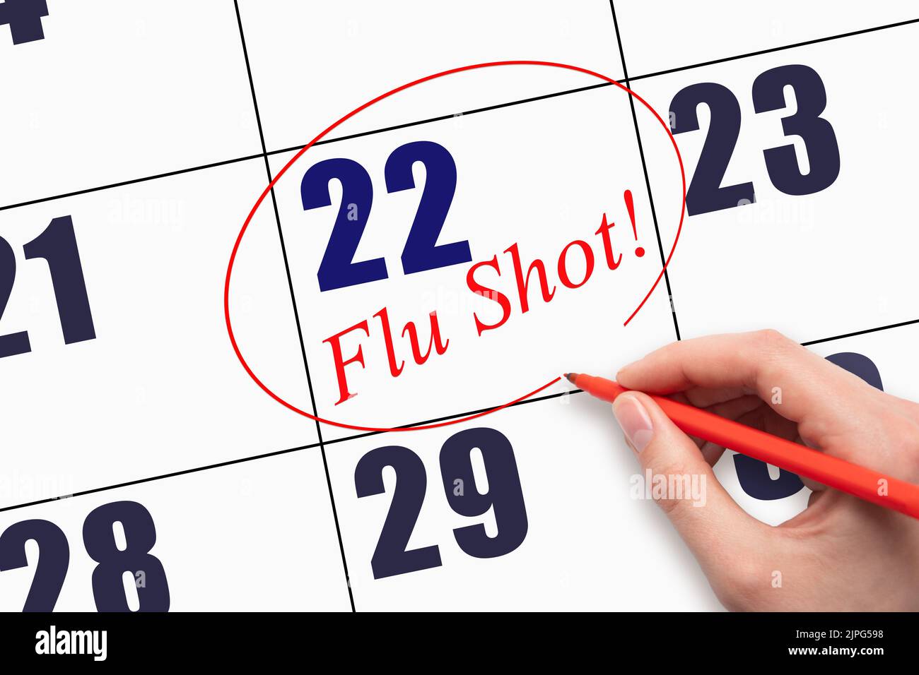 22nd day of the month.  Hand writing text FLU SHOT and circling the calendar date. Mark the date on the day planner to have a flu shot. Healthcare Med Stock Photo