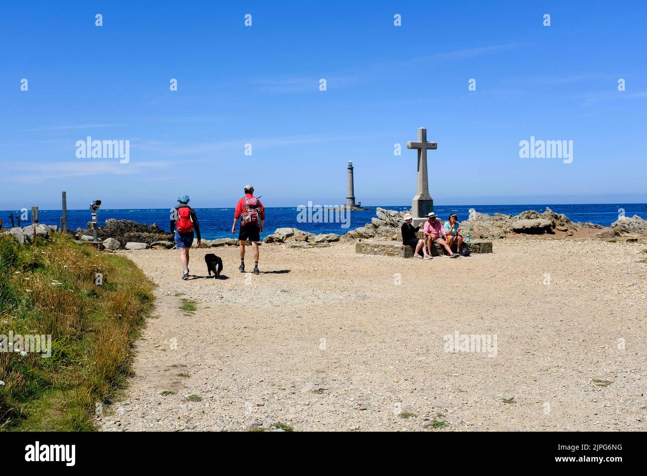 Frankreich, La Hague, 05.07.2022: Spaziergaenger und Wanderer am Cap de la Hague mit dem Leuchtturm von Goury im Hintergrund auf der Halbinsel Cotenti Stock Photo