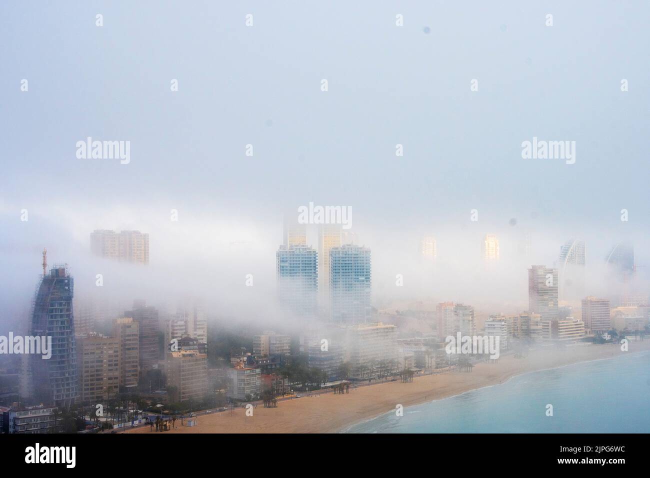 Fog billowing over and through Benidorm, Spain Stock Photo