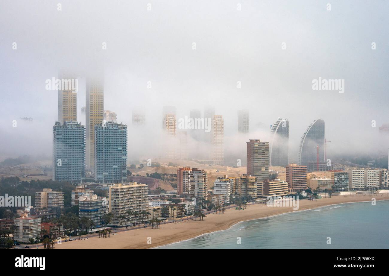 Fog billowing over and through Benidorm, Spain Stock Photo