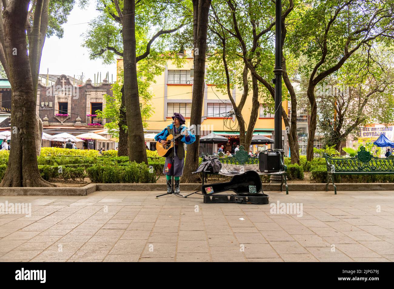 A busker playing the guitar and singing in Jardin Centenario in Coyoacan, Mexico City, Mexico Stock Photo