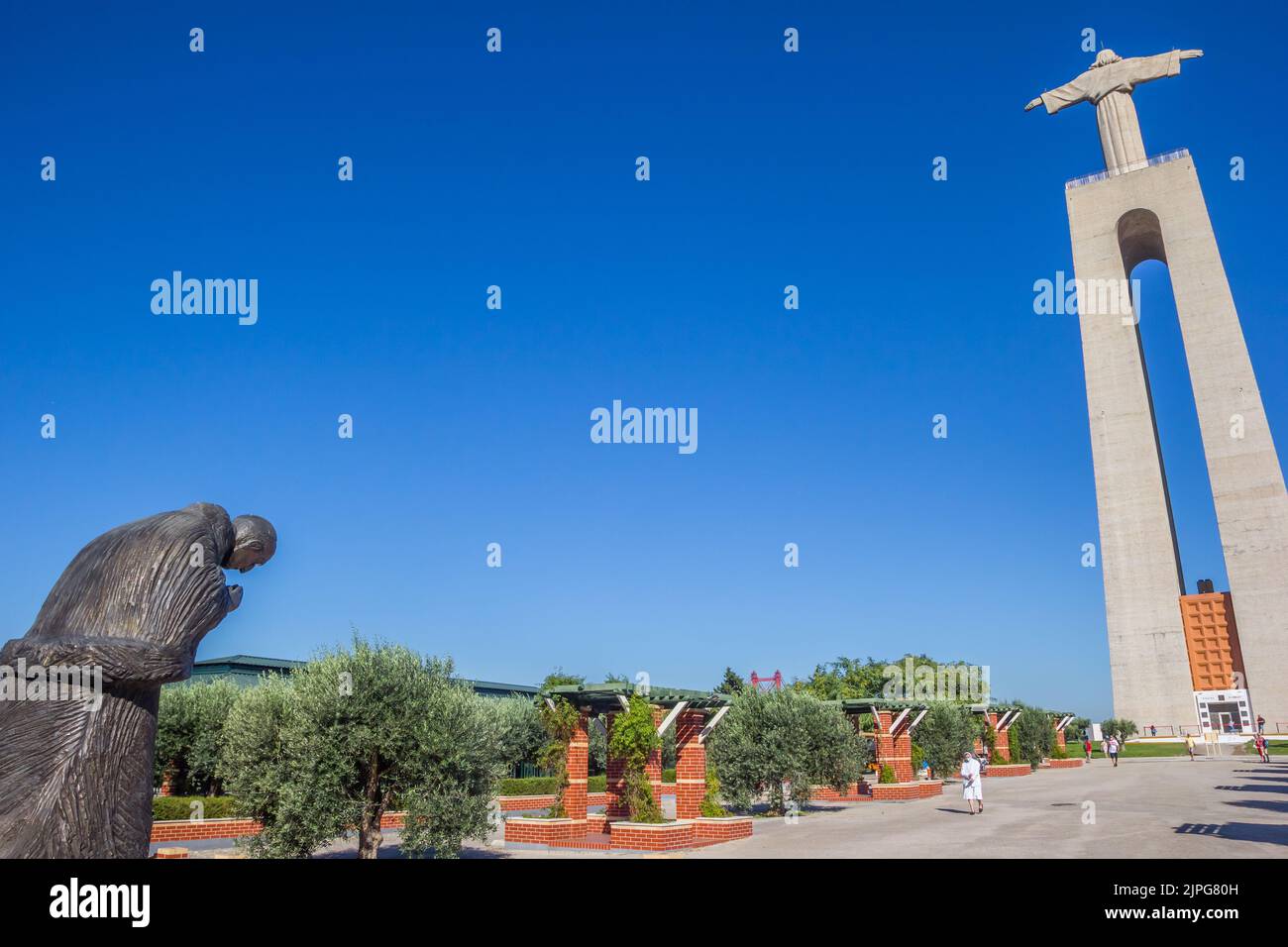 Sculpture of a monk bowing to the Christ statue in Lisbon, Portugal Stock Photo