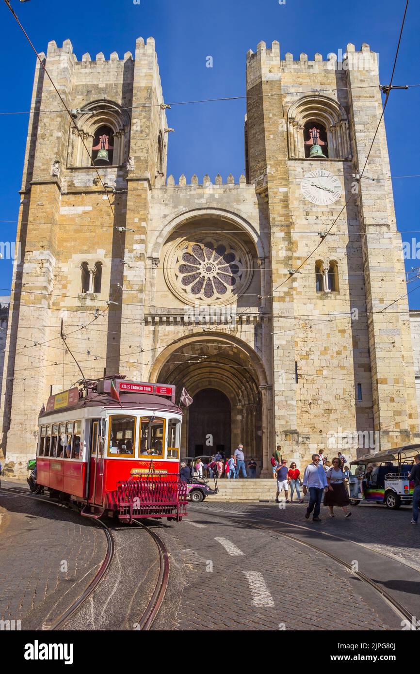 Traditional red streetcar in front of the cathedral in Lisbon, Portugal Stock Photo