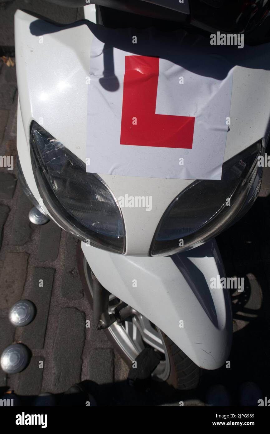 An L plate sticker on a scooter indicating the person in charge of the motorbike is a novice rider Stock Photo