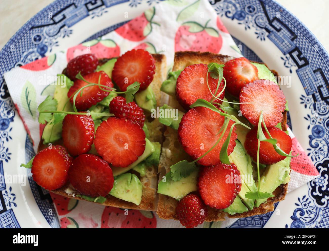 Strawberries and avocado on toast Stock Photo