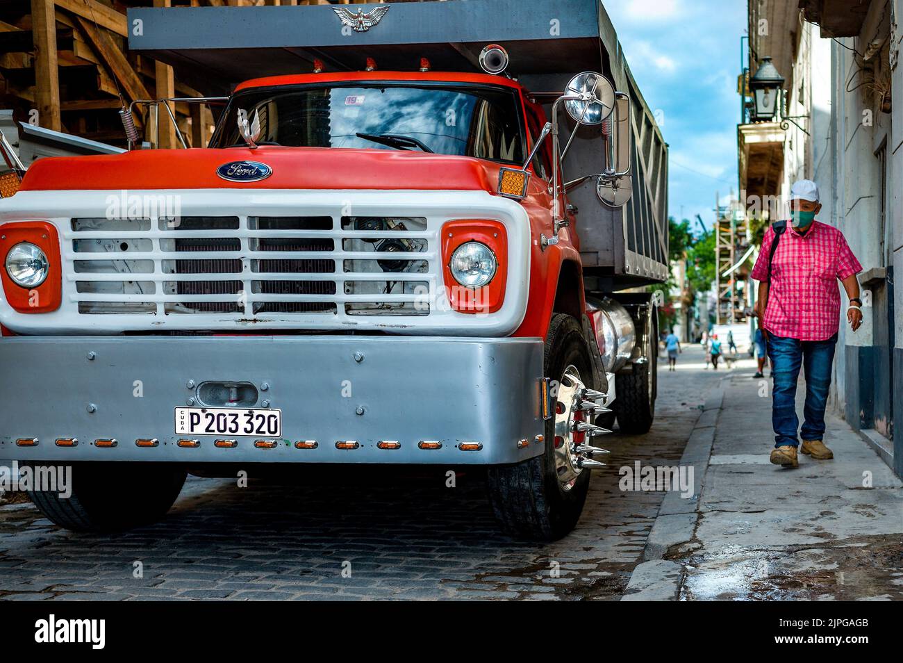 Ford vintage renovated truck in one of the Old Havana streets with a Cuban passing by. Stock Photo