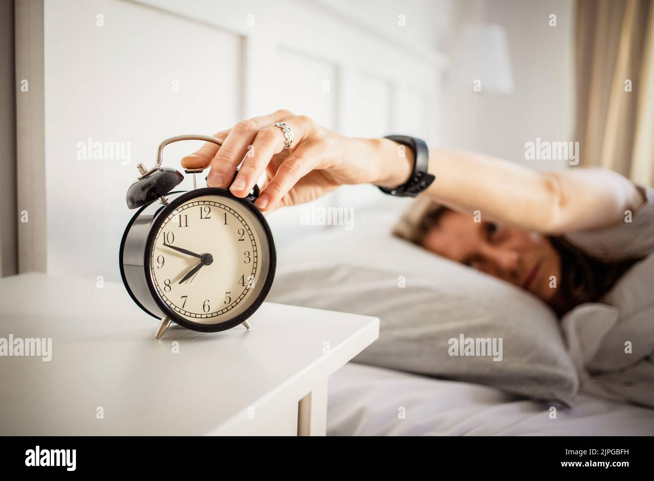 alarm clock and woman sleeping in bed sleep quality Stock Photo Alamy