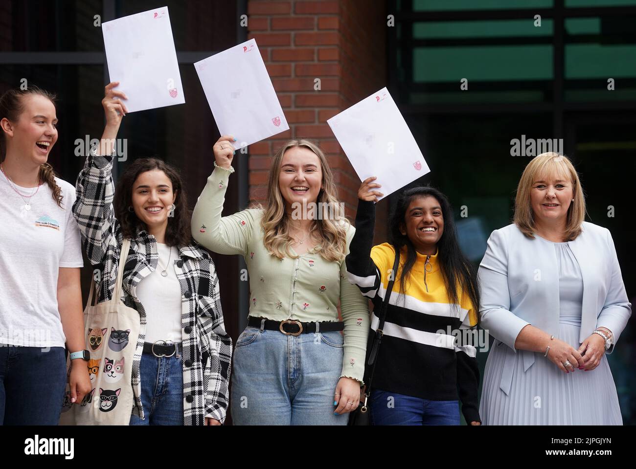 PIXELATION BY PA PICTURE DESK Education Minister Michelle McIlveen with former pupils of Strathearn Grammar School in east Belfast as they receive their A-level results. Picture date: Thursday August 18, 2022. Stock Photo
