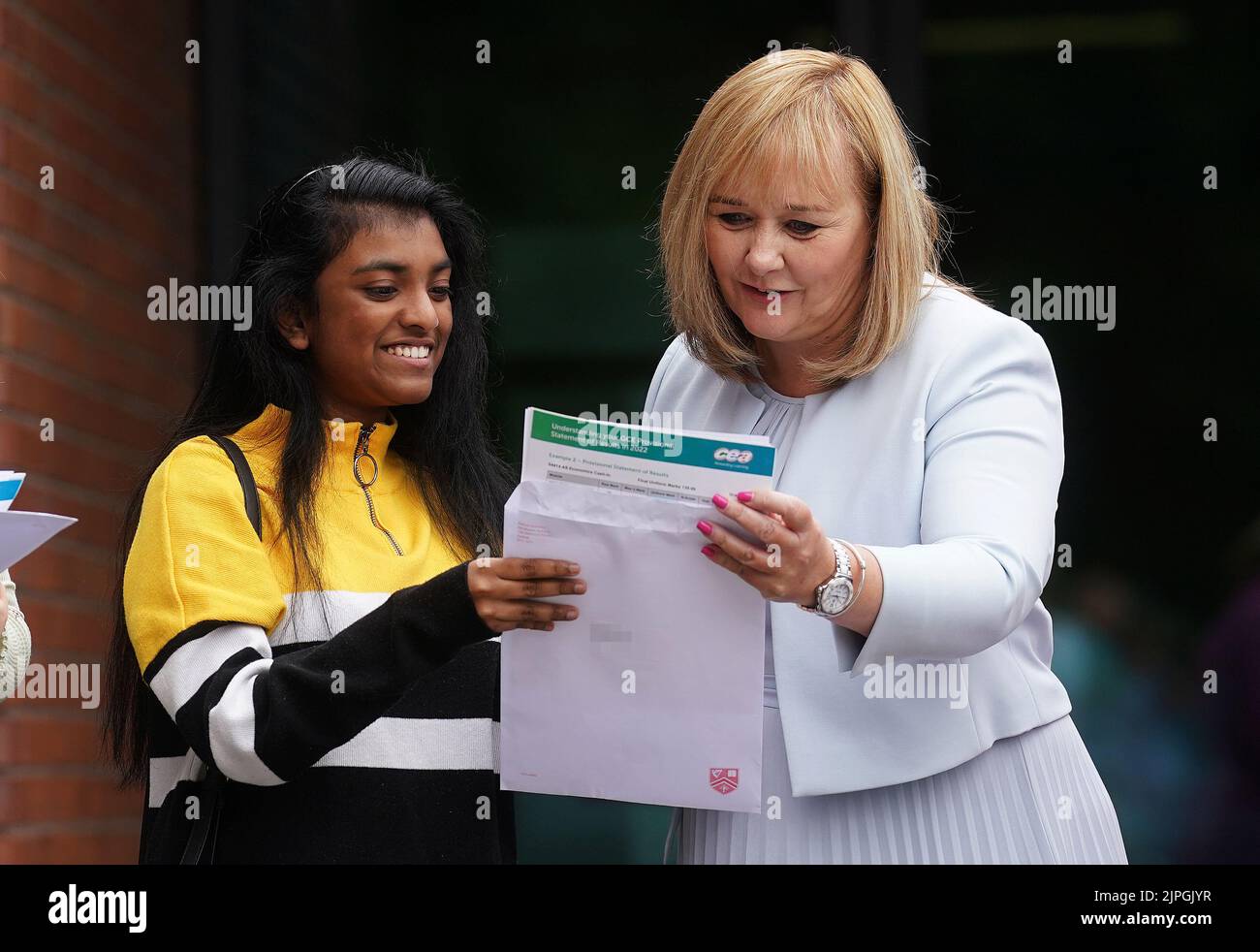 PIXELATION BY PA PICTURE DESK Education Minister Michelle McIlveen (right) with Rachel Lipson (centre) as she opens her A-level results at Strathearn Grammar School in east Belfast. Picture date: Thursday August 18, 2022. Stock Photo