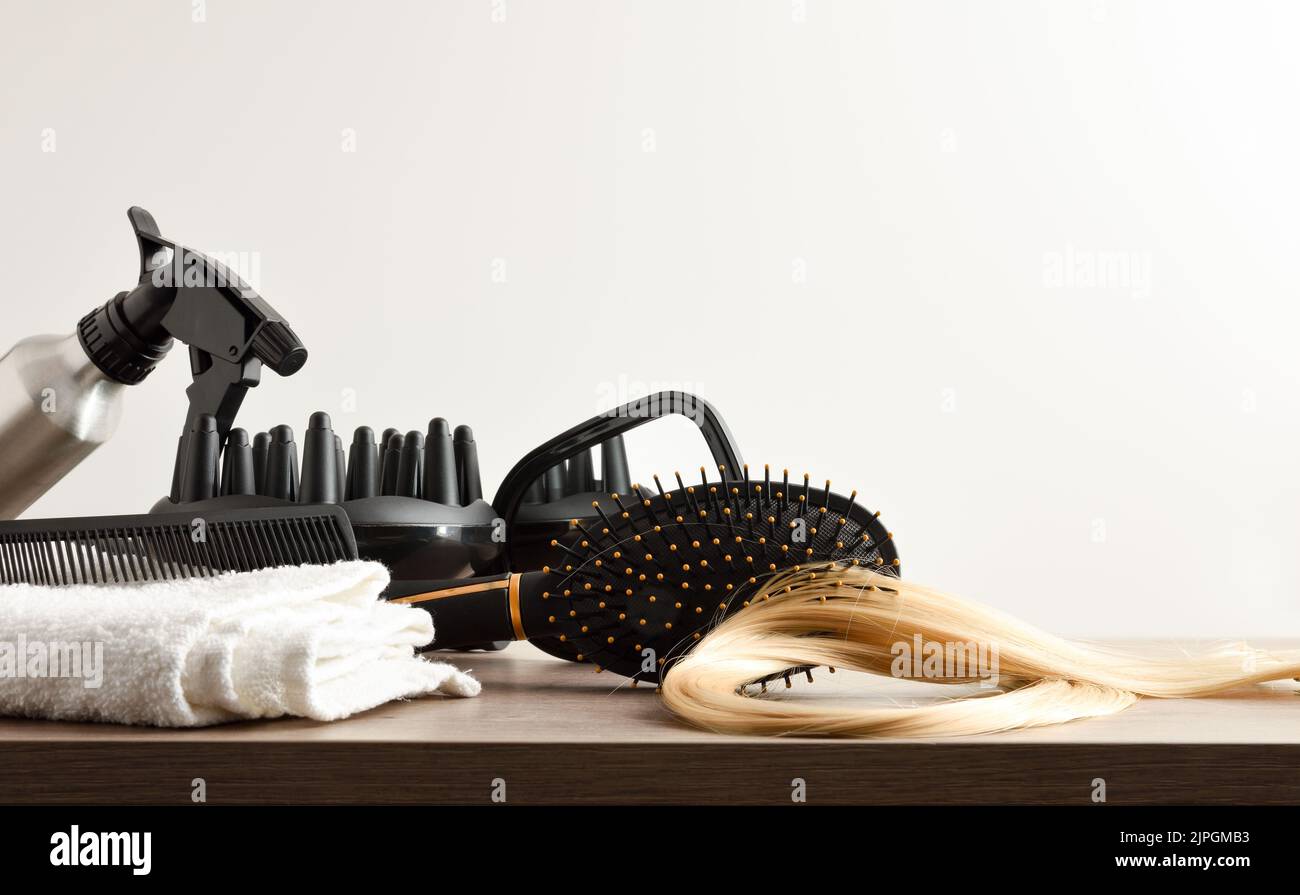 Hairdressing accessories on white workbench in hairdressing salon with window in the background. Front view. Horizontal composition. Stock Photo