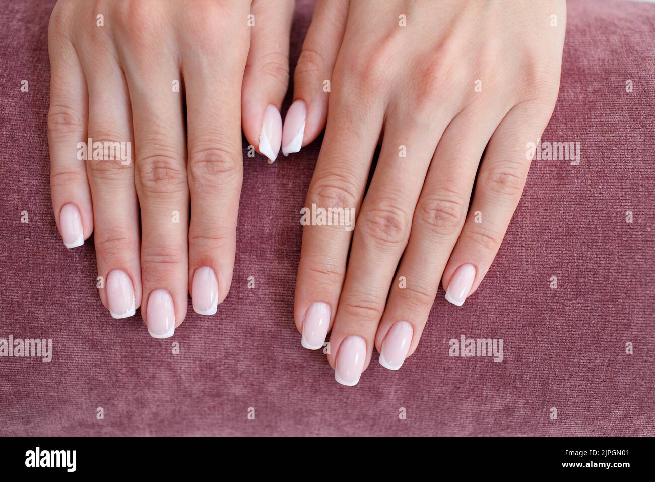 Female hand fingers nails with manicure after nail salon procedure on
