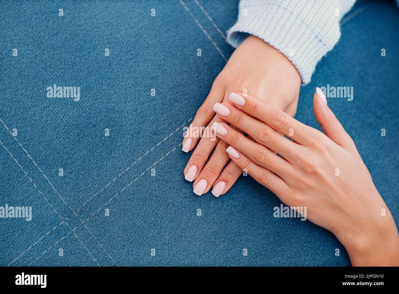 Female hand fingers nails with manicure after nail salon procedure