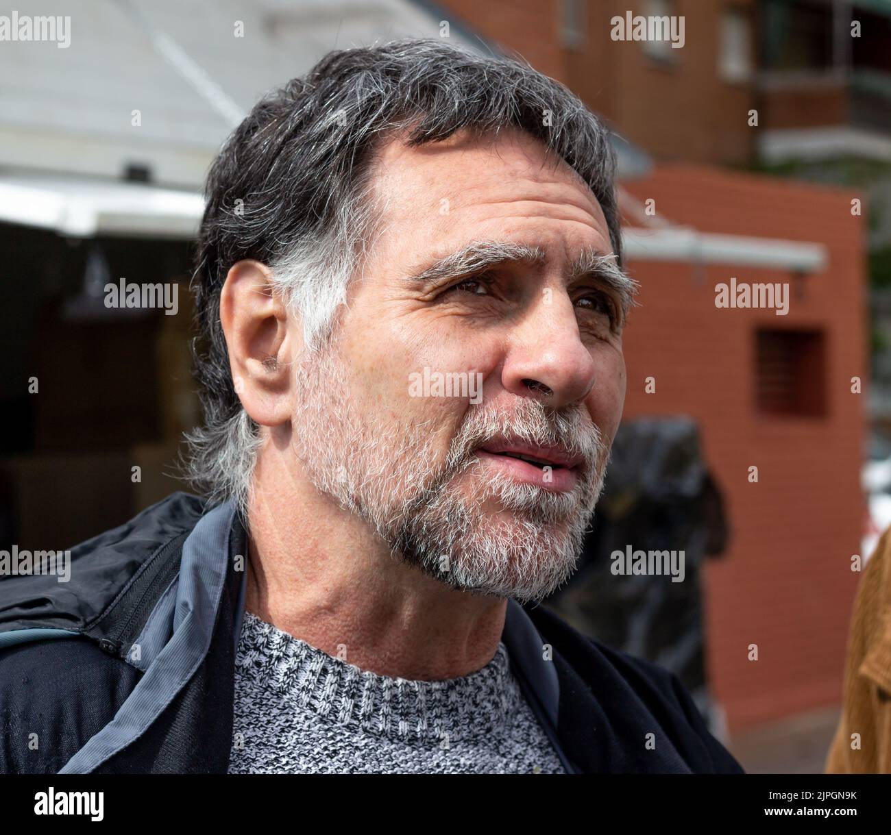 Adult man with white beard and gray hair looking to the horizon Stock