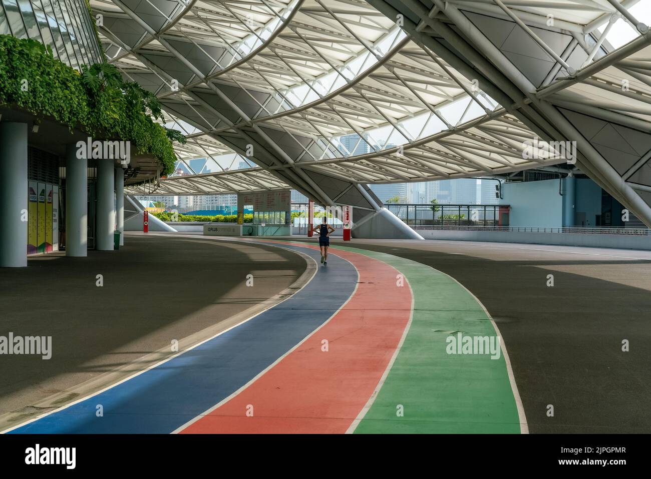 A jogger jogs on the largest fully-sheltered running track outside National Stadium, Singapore. Stock Photo