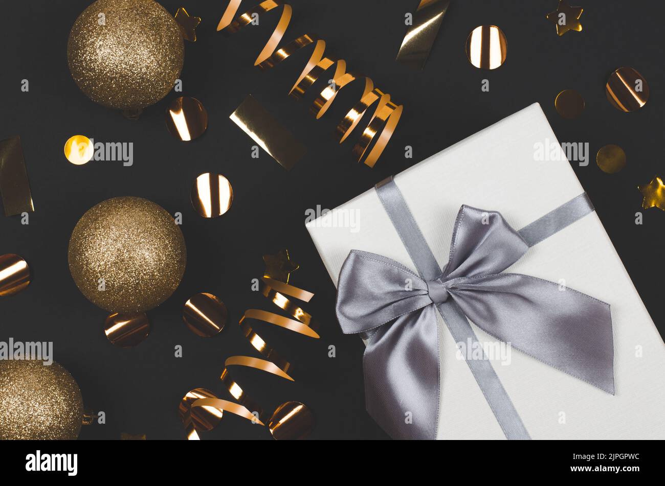 Christmas composition. Large white gift box and gold christmas decor on ...