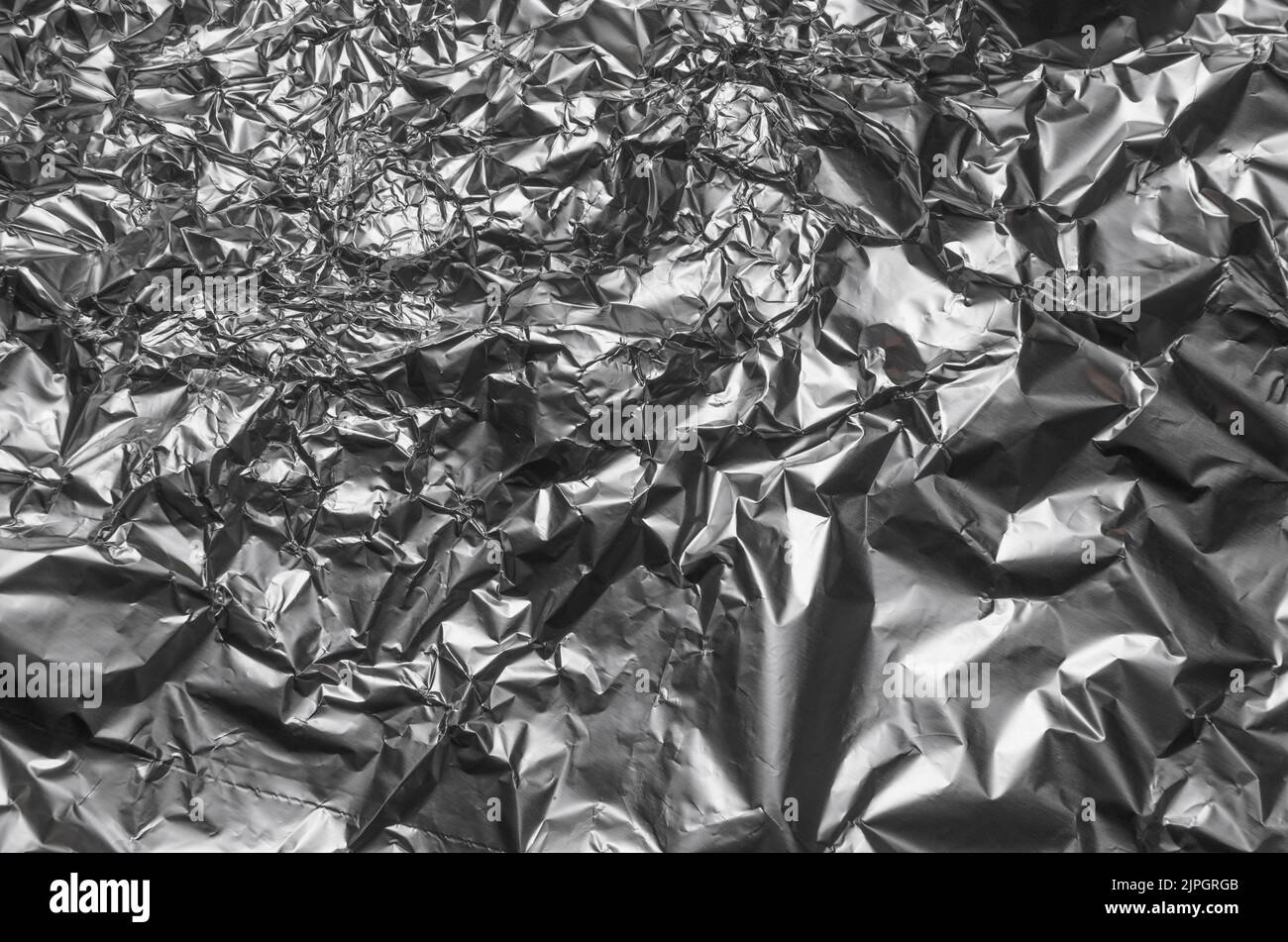 Abstract background of crumpled silver aluminium foil, flat lay view from directly above Stock Photo