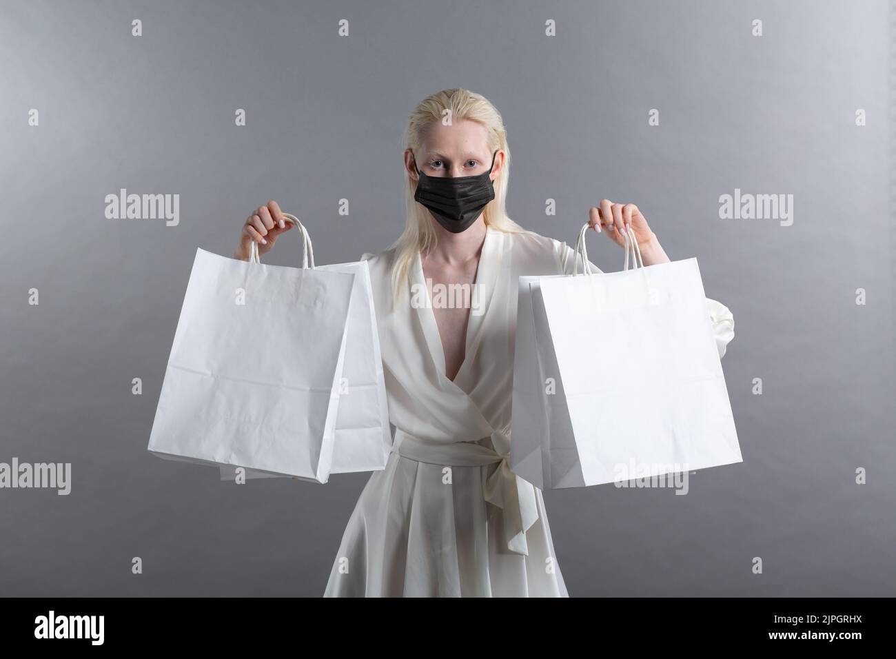 White caucasian albino blond woman holds shopping bag. Sale and discounts on market and Black Friday concept. Stock Photo