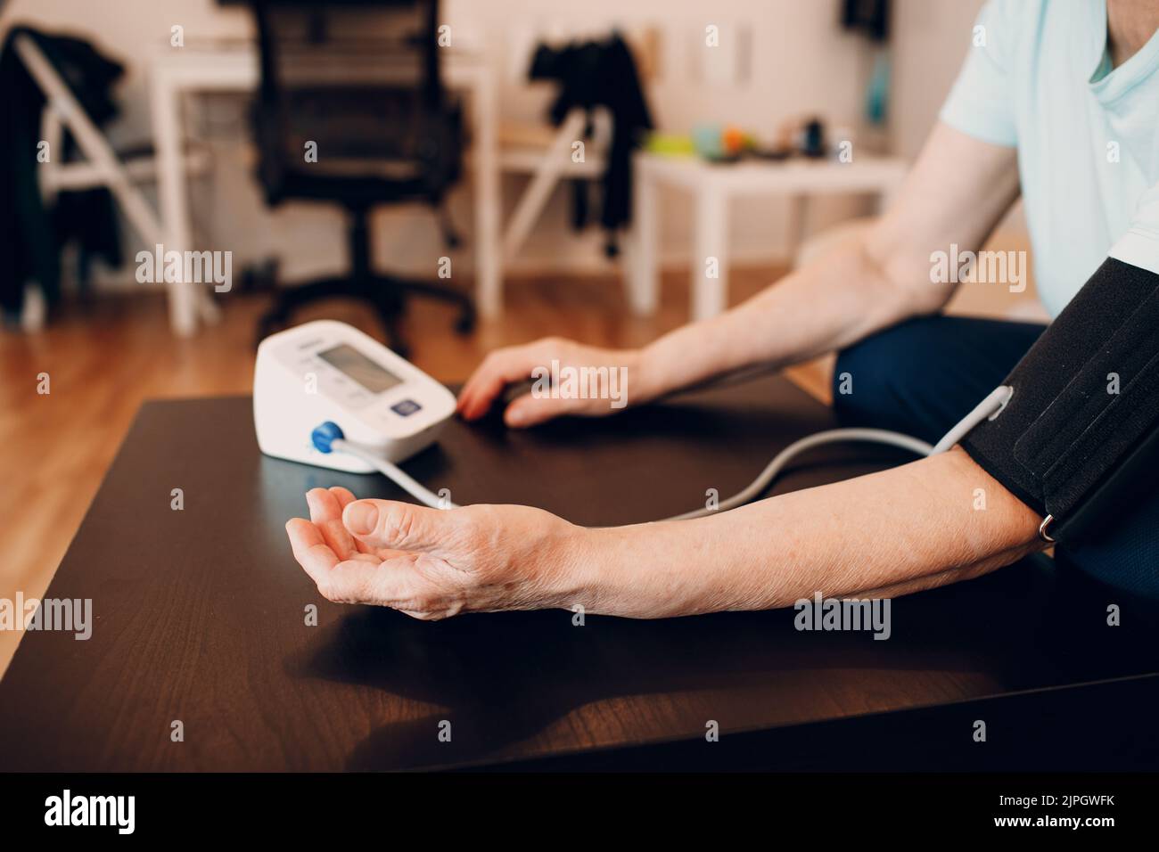 Senior woman taking measures blood pressure at home. Self care of