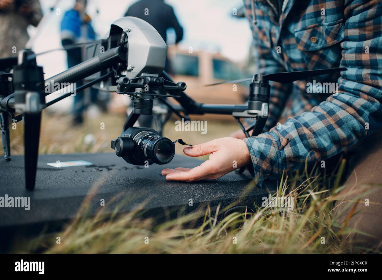Man pilot checking quadcopter drone camera before aerial flight and filming Stock Photo