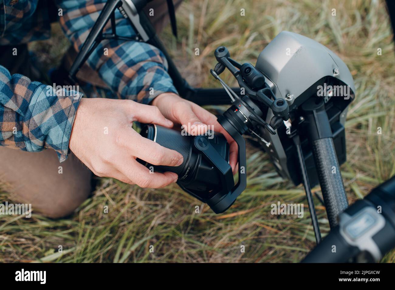 Man pilot checking quadcopter drone and putting on camera lens before