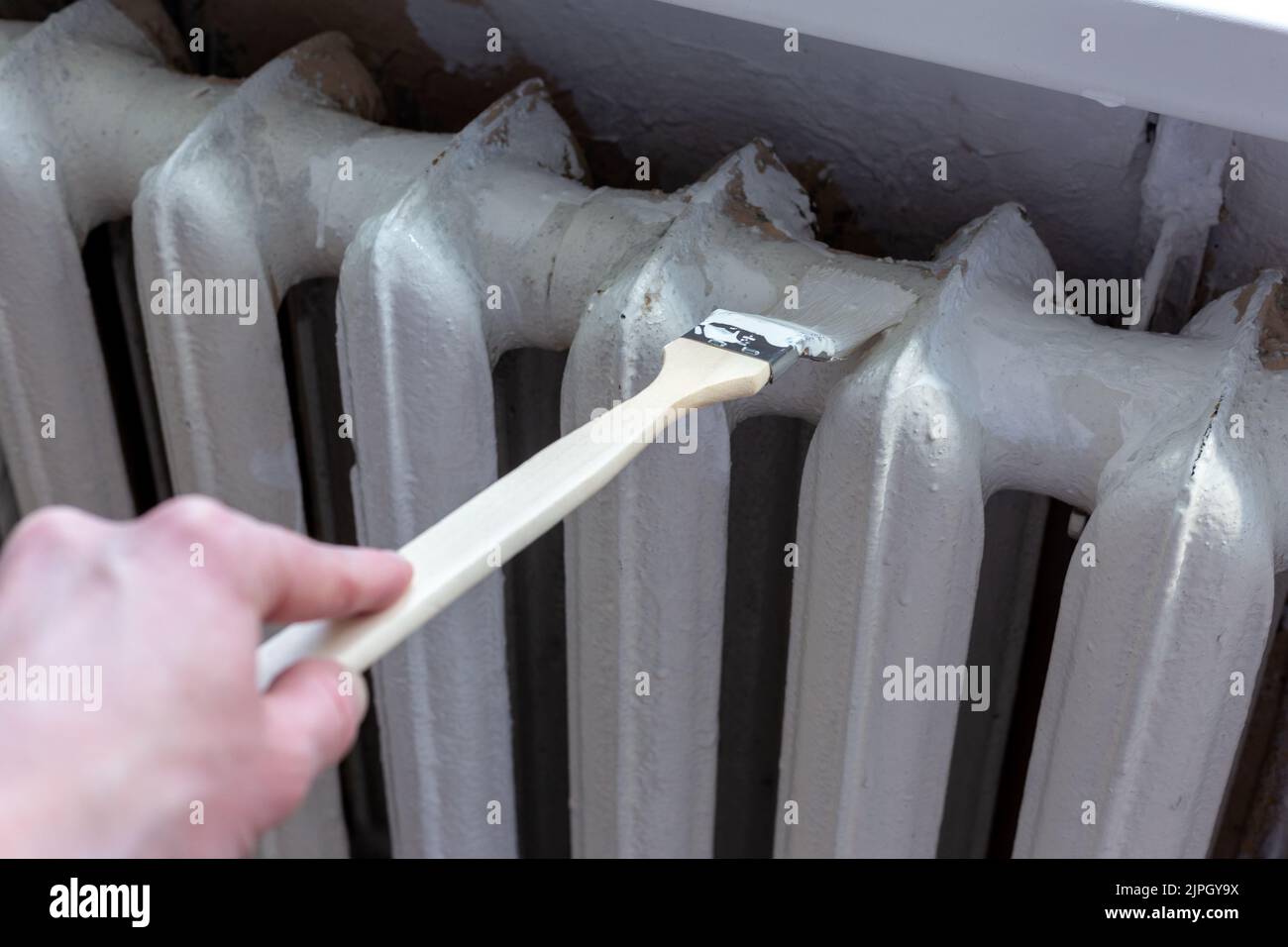 Painting radiators with a special brush. Battery painting Stock Photo