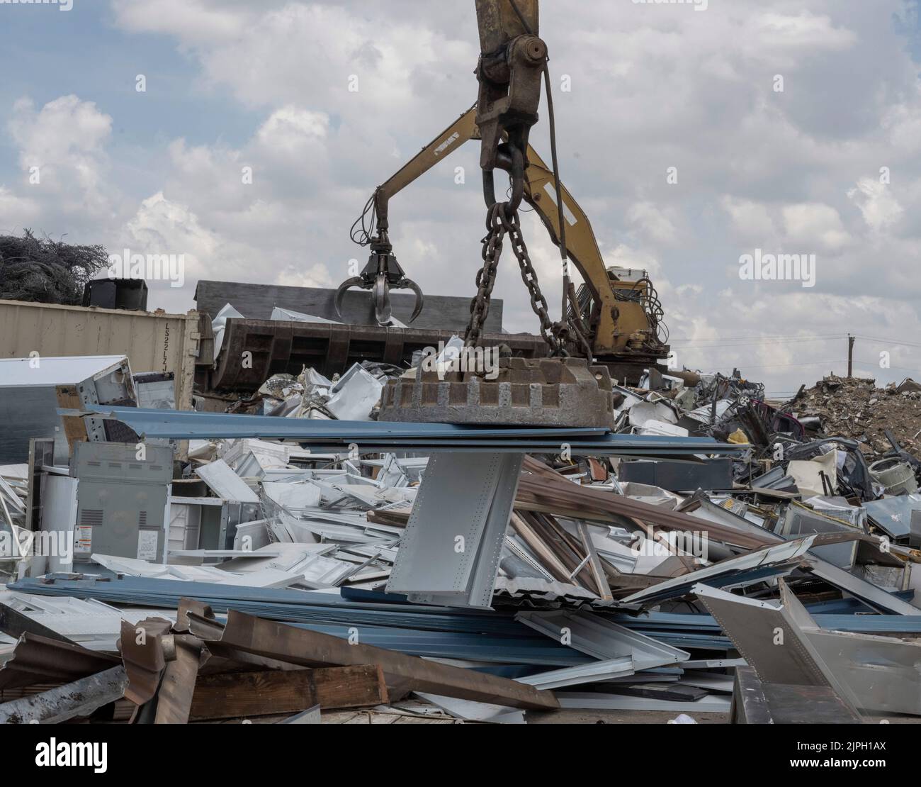 A large Caterpillar track material handler with an attached magnet takes metal construction debris off a utility trailer for recycling at CMC Metals in north Austin, Texas. The yard recycles thousands of pounds of old materials daily. ©Bob Daemmrich Stock Photo