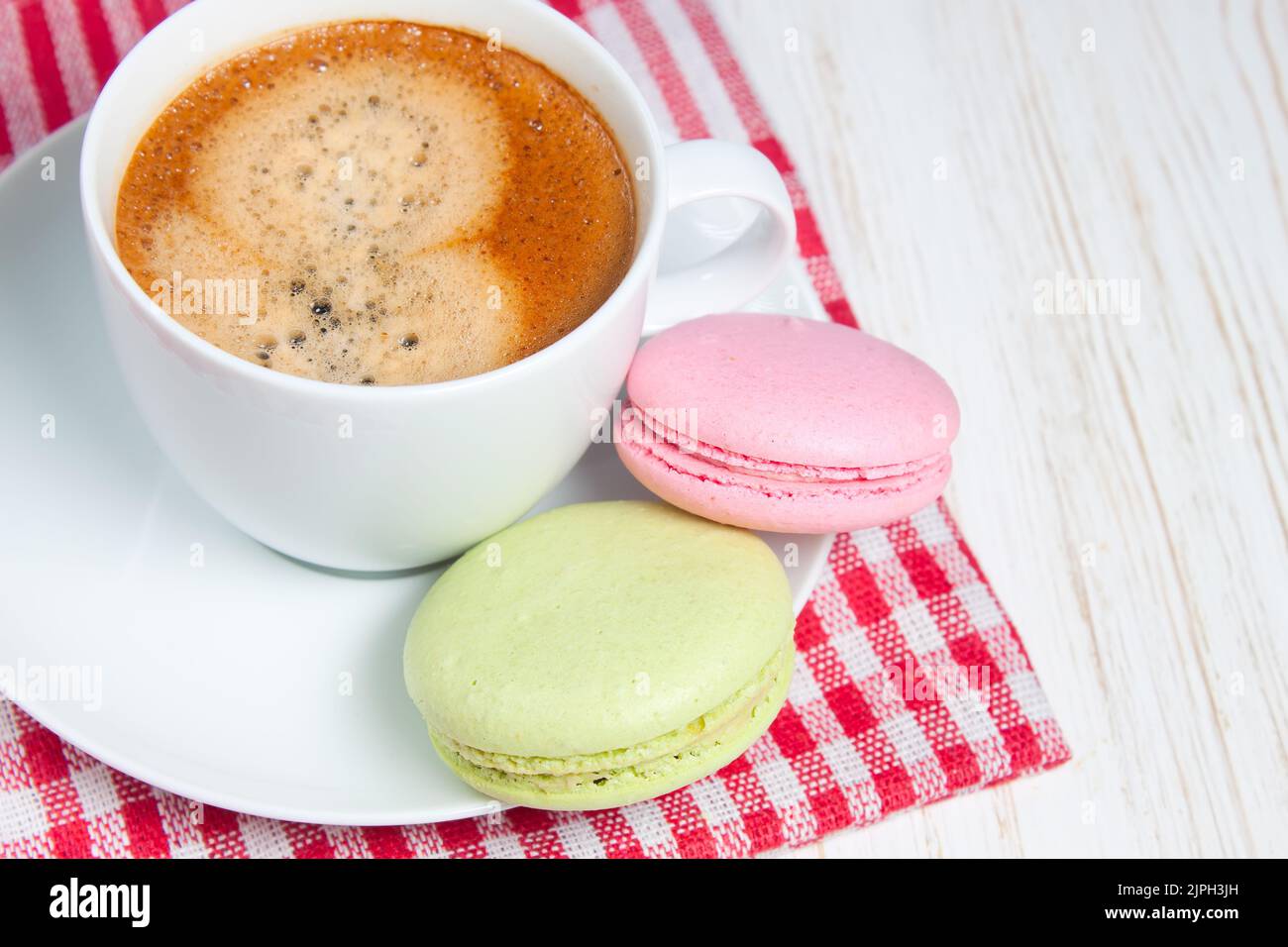 Traditional french macaroons and one white cup of coffee cappucino, late, espresso Stock Photo