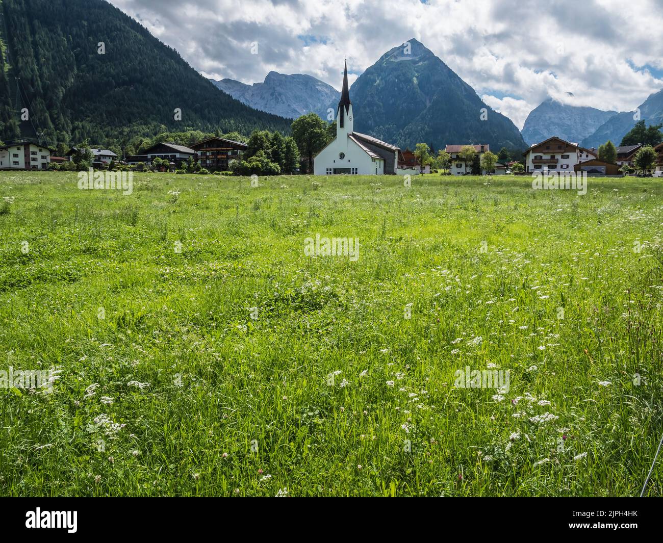 Colourful scene looking to the Dreifaltigkeitskirche [church of the Holy Trinity] church in the resort town of Pertisau on the shore of Lake Achensee Stock Photo
