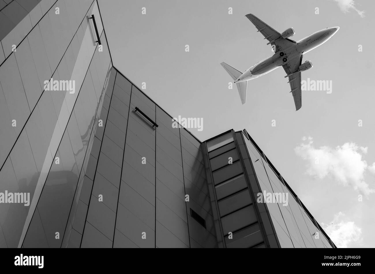 Airplane in the sky with modern buildings Stock Photo