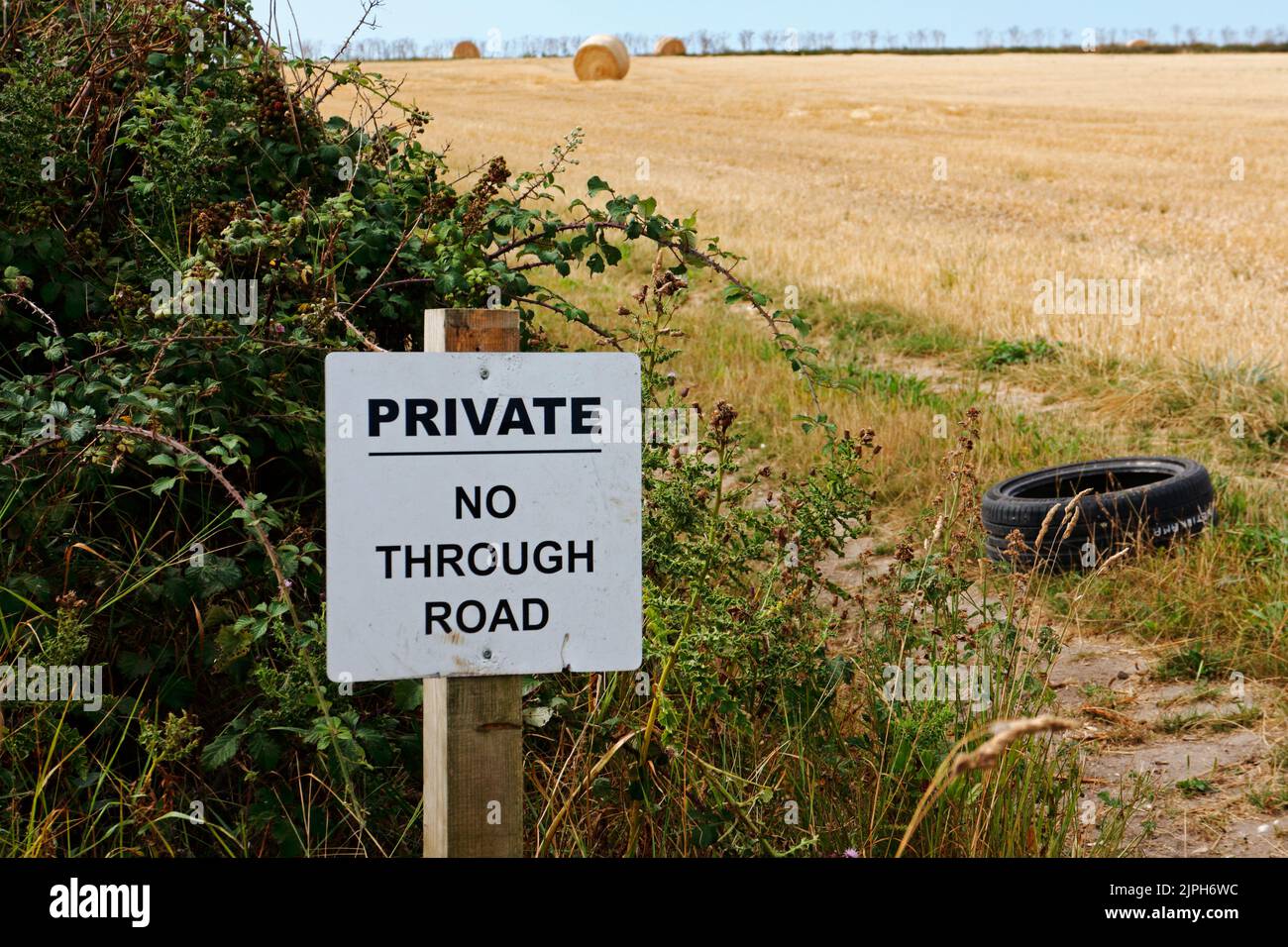 A Private No Through Road sign by a track beside working farmland on the North Norfolk coast at Salthouse, Norfolk, England, United Kingdom. Stock Photo
