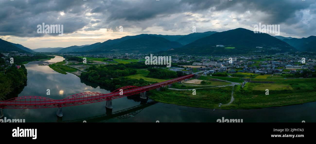 Panoramic aerial view of red bridge and rural landscape at dusk Stock Photo