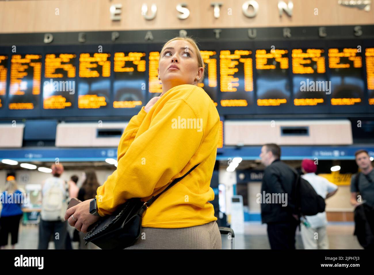 Hopeful passengers look at the Departures board at Euston Station during another day of rail