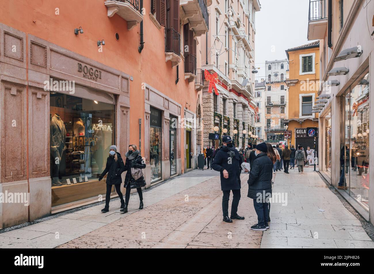tourists crowd the fashionable, colourful pedestrianised Via Giuseppe Mazzini - Verona city, Veneto region, northern Italy - december 28, 2021 Stock Photo