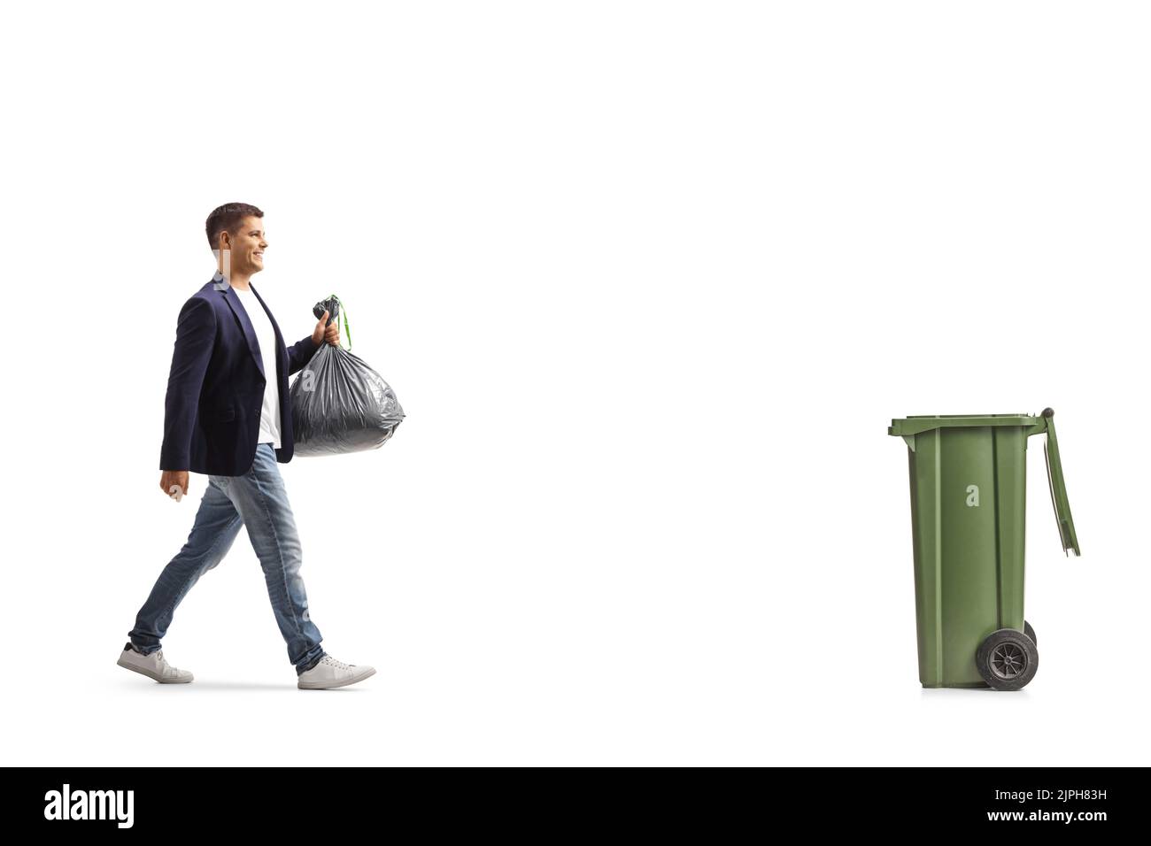 Full length profile shot of a man walking towards a bin and carrying a plastic waste bag isolated on white background Stock Photo