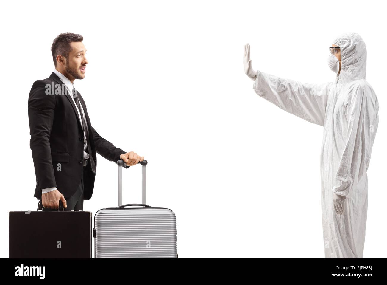 Profile shot of a man in a white decontamination suit gesturing stop to a businessman with a suitcase isolated on white background Stock Photo