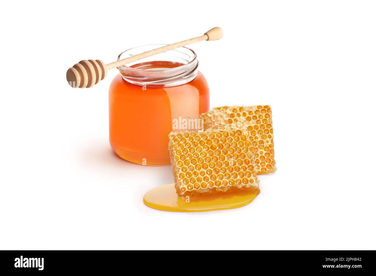 Small jar of honey with a dipper and pieces of honeycomb isolated on white background Stock Photo