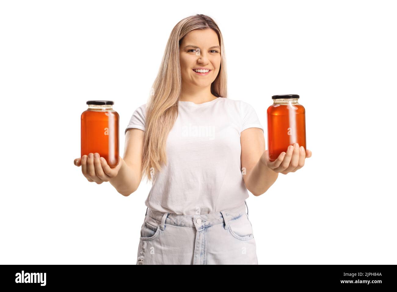 Young casual woman holding two jars of honey isolated on white background Stock Photo