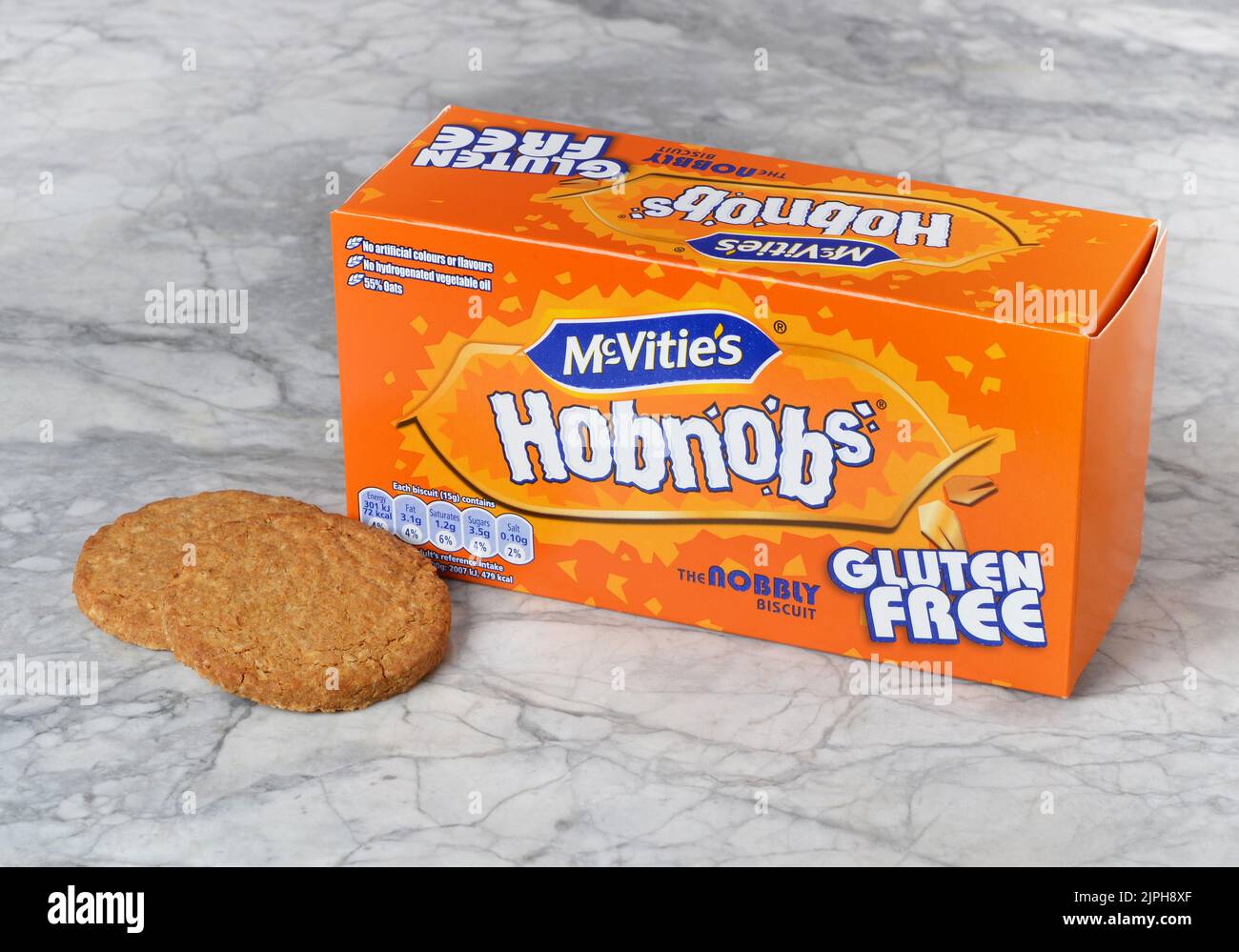 Pack shot of McVities Gluten Free Hobnob's biscuits showing the packaging box with two biscuits in front of the box Stock Photo