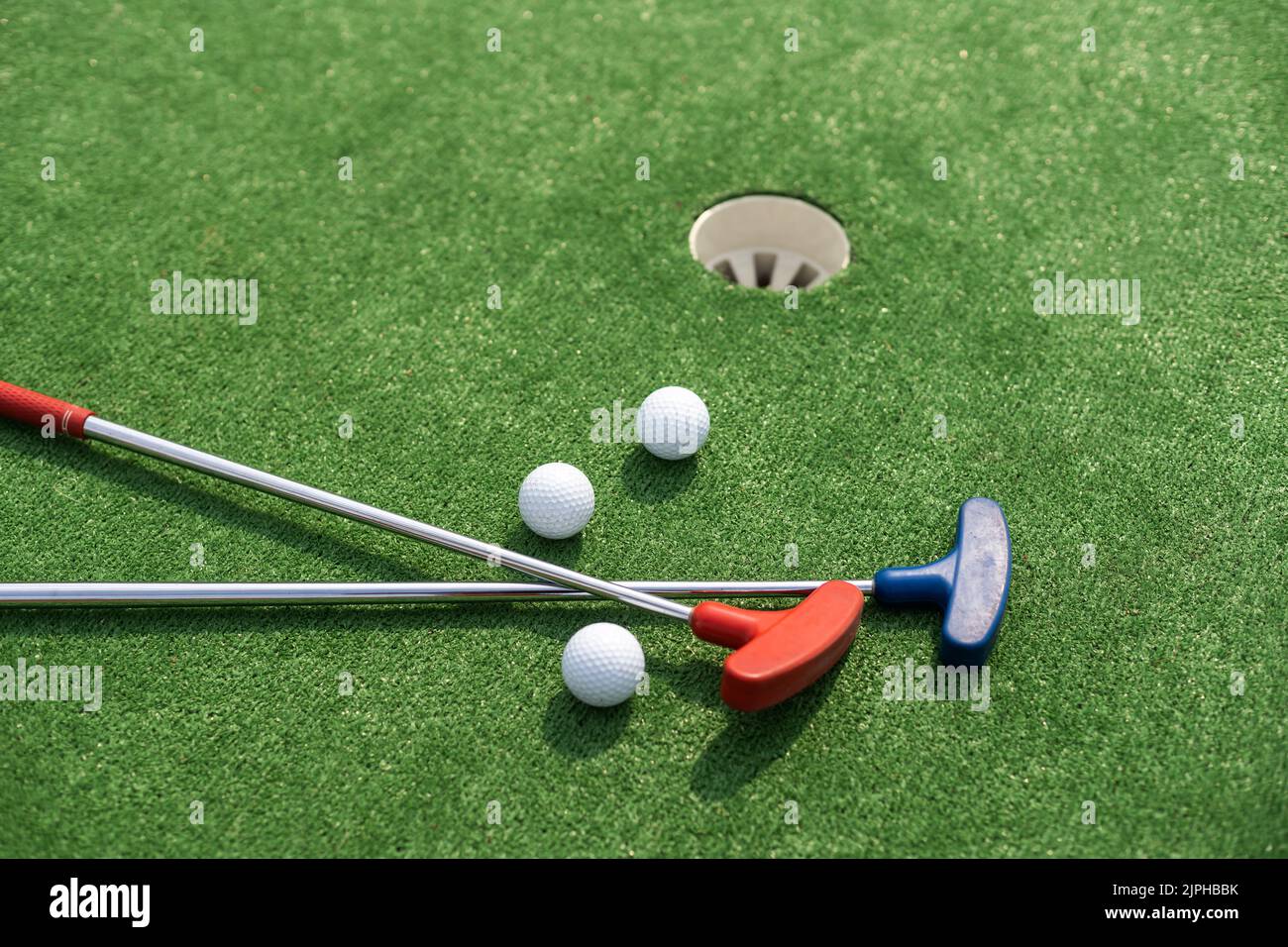 A club prepares to hit a ball during a mini golf game Stock Photo Alamy