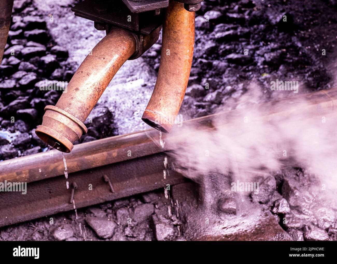Steam pipes hissing steam from an old steam engine on the Bluebell line Stock Photo