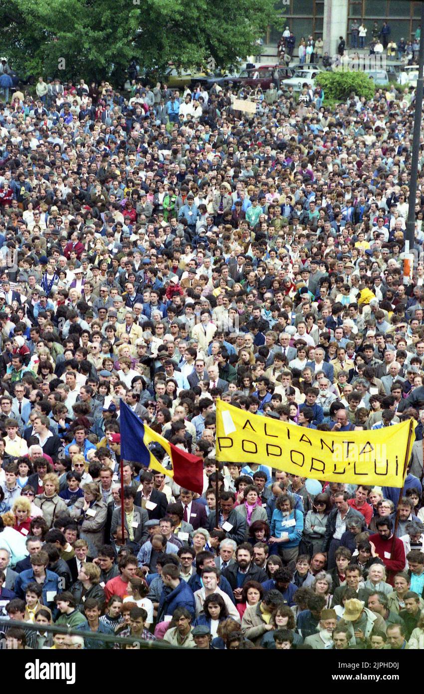 Bucharest, Romania, April 1990. 'Golaniada', a major anti-communism protest  in the University Square following the Romanian Revolution of 1989. People would gather daily to protest the ex-communists that grabbed the power after the Revolution. The main demand was that no former party member would be allowed to run in the elections of May 20th. The banner says 'The people's alliance'. The Romanian flag with the Socialist emblem cut off was an anti-communist symbol during the revolution. Stock Photo