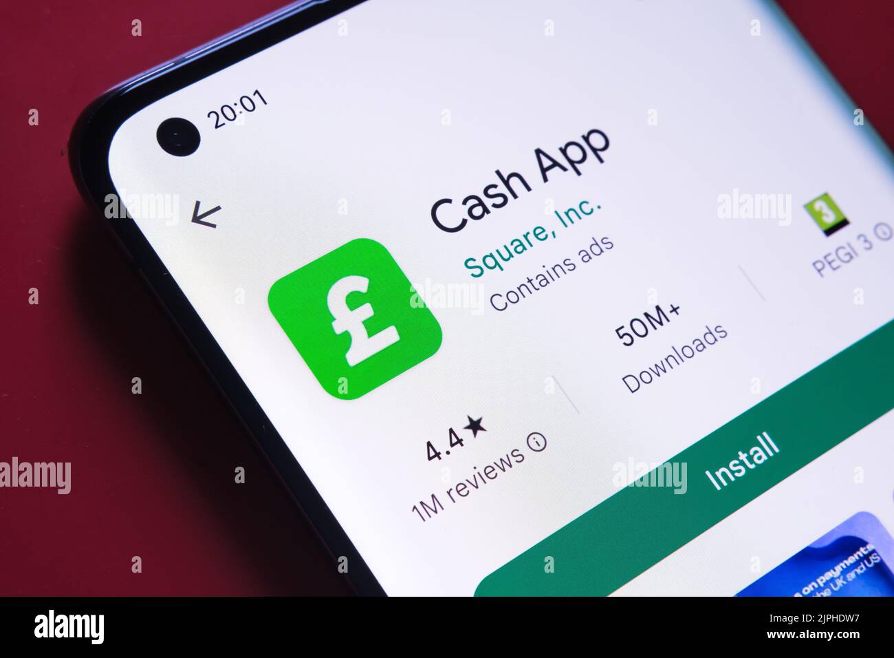 Cash app seen in Google Play Store on the smartphone screen placed on red background. Close up photo with selective focus. Stafford, United Kingdom, A Stock Photo