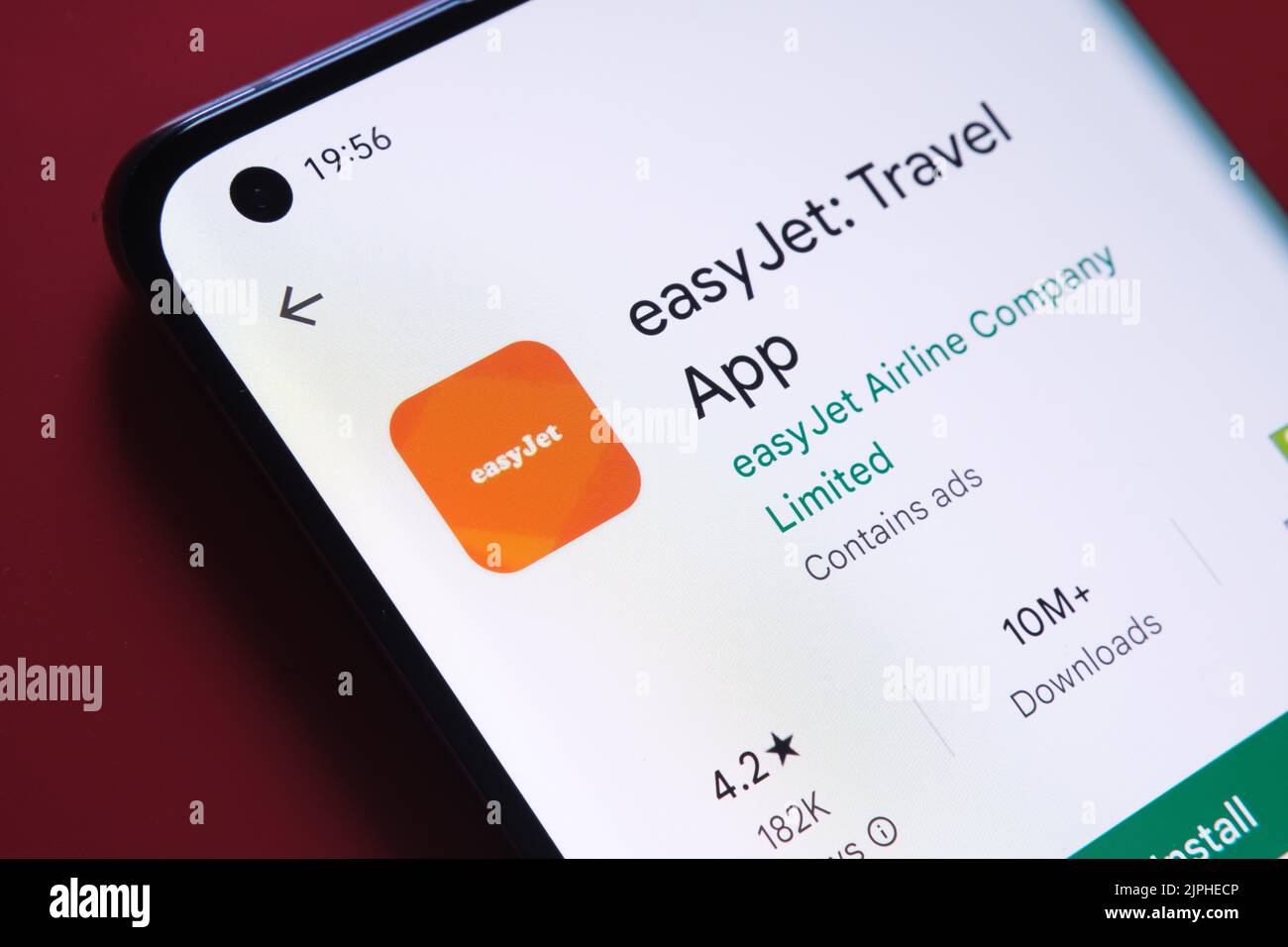 EasyJet app seen in Google Play Store on the smartphone screen placed on red background. Close up photo with selective focus. Stafford, United Kingdom Stock Photo