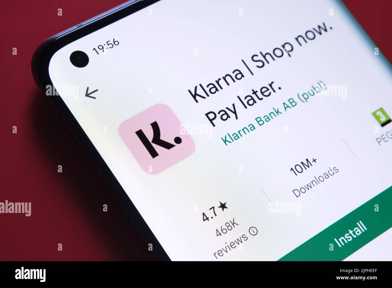 klarna app seen in Google Play Store on the smartphone screen placed on red background. Close up photo with selective focus. Stafford, United Kingdom, Stock Photo