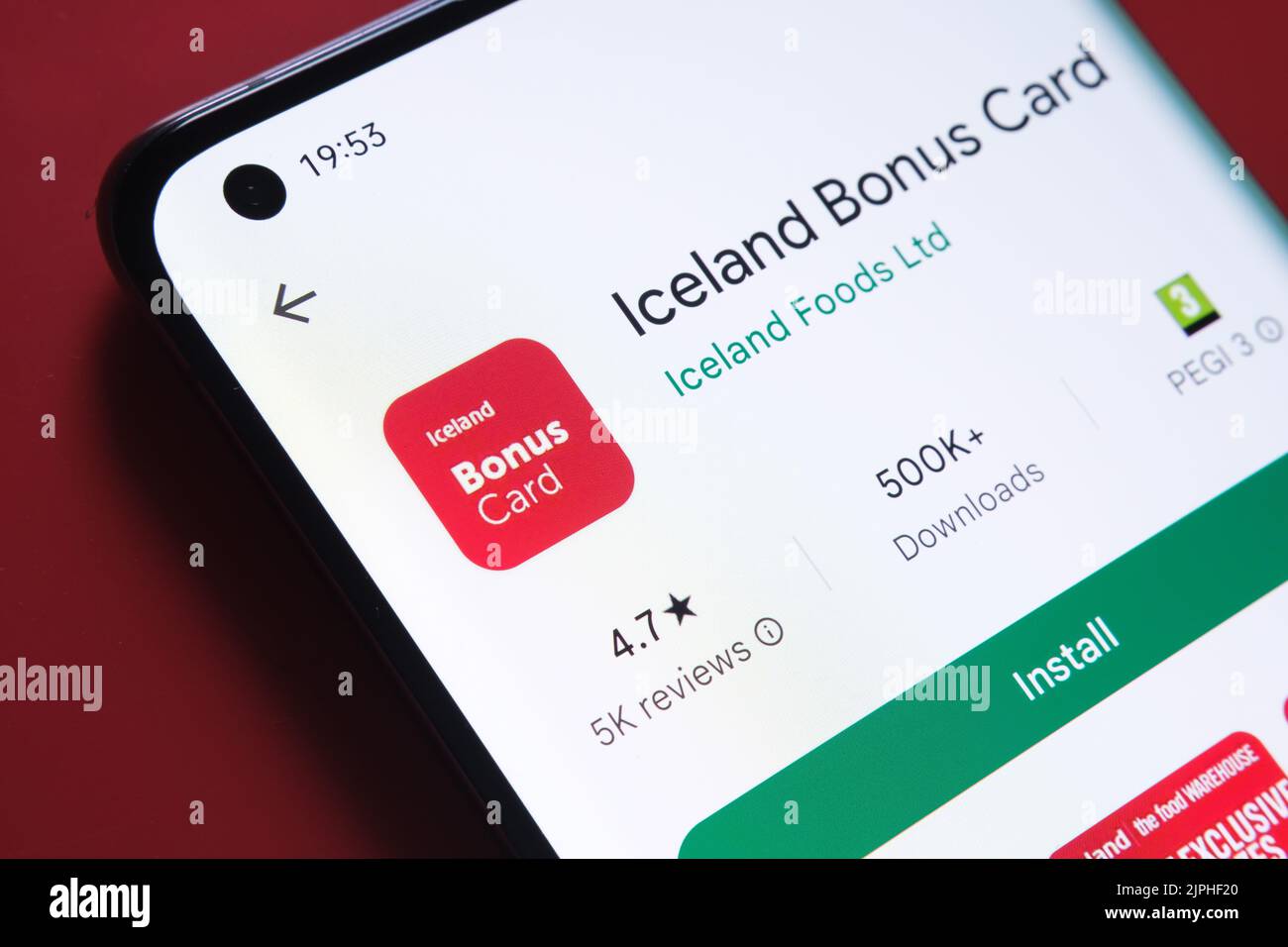 Iceland Bonus Card app seen in Google Play Store on the smartphone screen placed on red background. Close up photo with selective focus. Stafford, Uni Stock Photo
