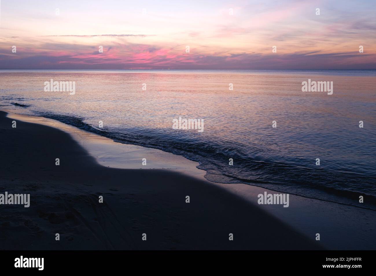 Baltic sea sunset sky, silver purple colors of sea calm water. Romantic beach landscape. Stock Photo