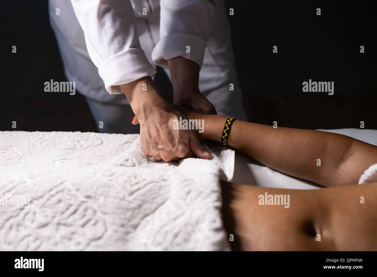 Goiânia, Goias, Brazil – July 18, 2022: Detail of hands of masseur, who is applying therapeutic massage on the hand of a patient who is lying down. Stock Photo